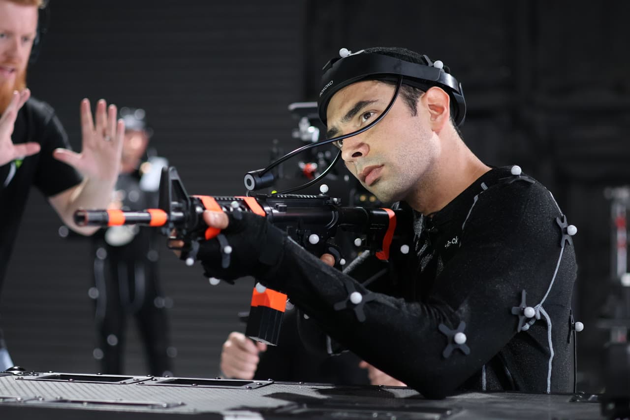 Performer in OptiTrack mocap suit with facial capture headset during a shoot