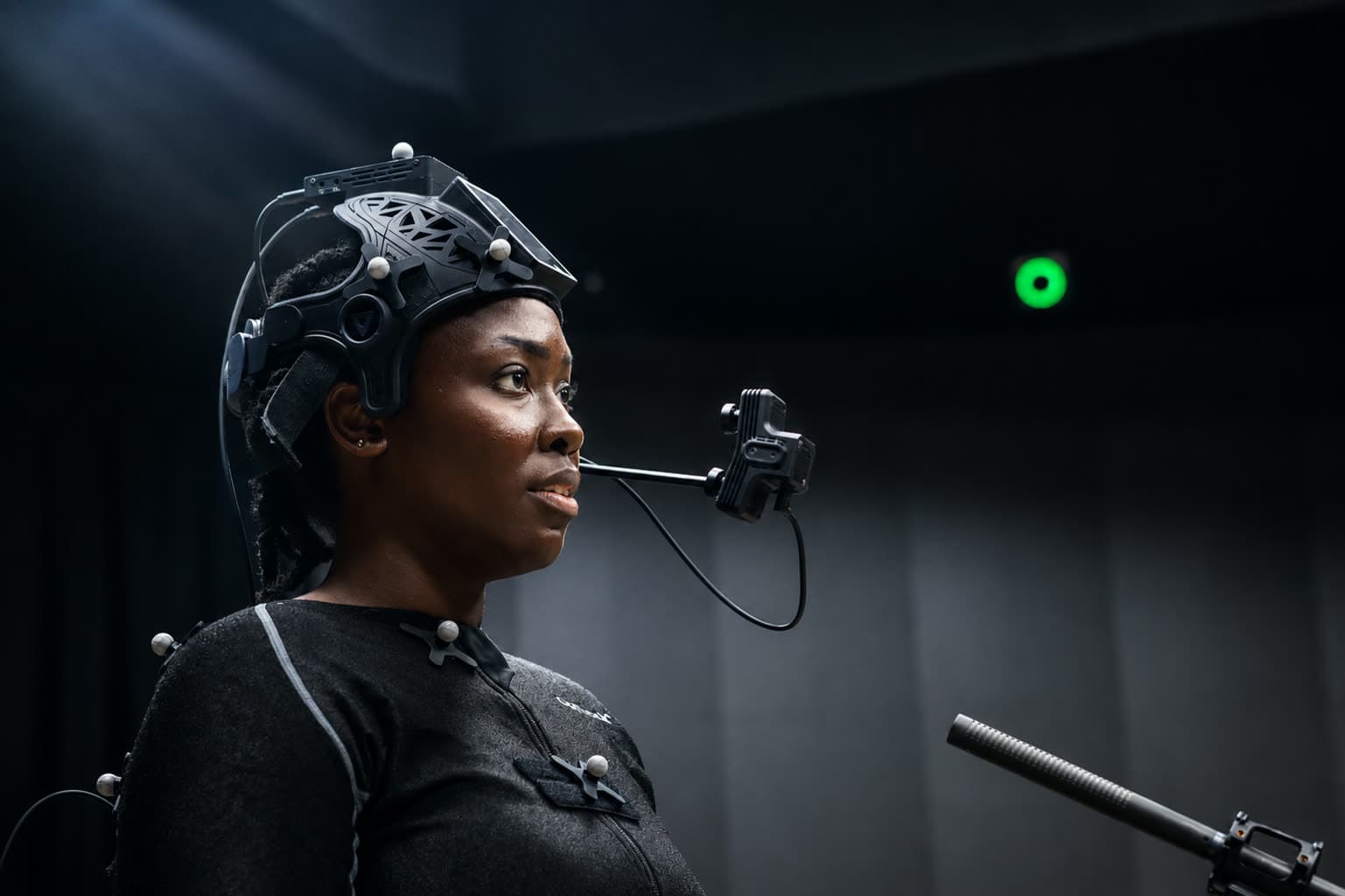 Close side profile of the FACEGOOD SMART P3 head-mounted camera, showing the tracking markers on the helmet and the stereo camera boom positioned in front of the performer's face
